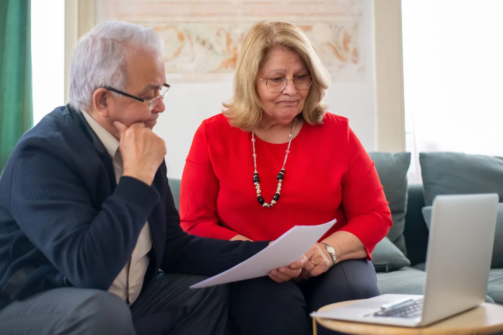 An older couple reviews paperwork together at home.